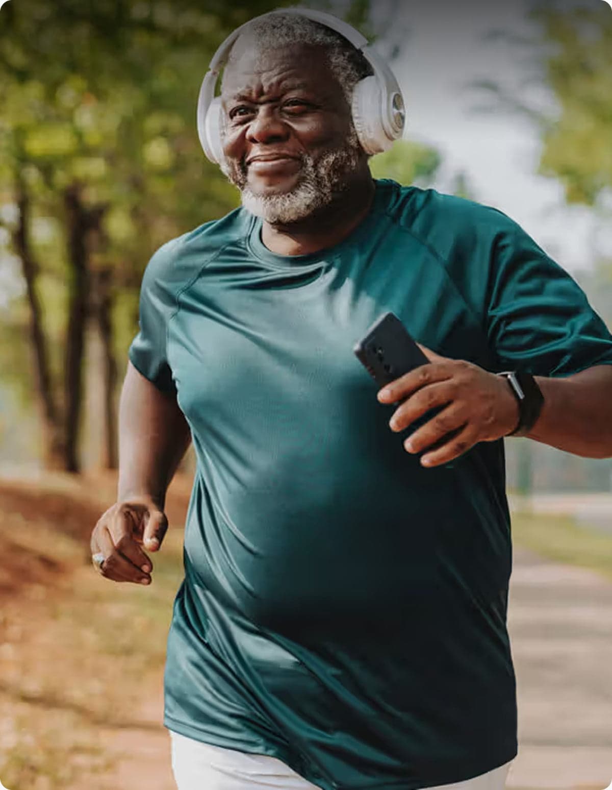 A man jogging outdoors, smiling